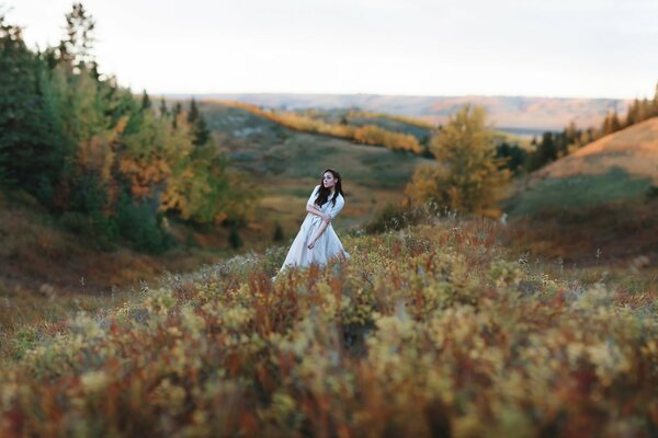 A girl in the grass among the hills