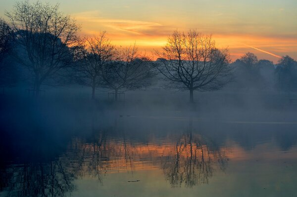 Schöner Sonnenuntergang am nebligen See