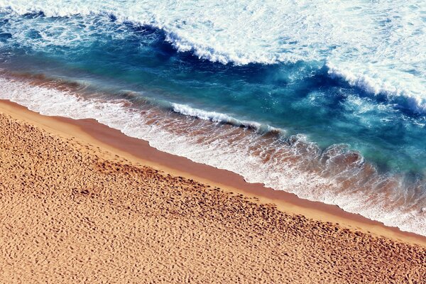 Warm sand covered with sea foam