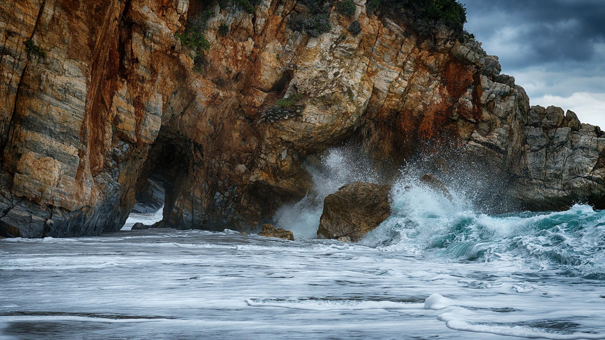 ciel mer roches vagues tempête éclaboussures arche