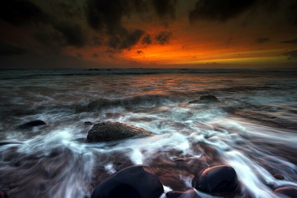 Water washing the stones at sunset