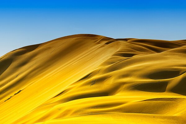 Hot flowing sand in a hot desert under a full sky