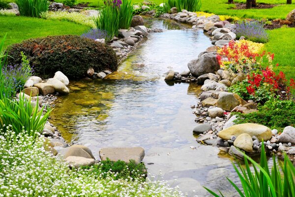 Ruisseau qui coule sur la pelouse avec des fleurs