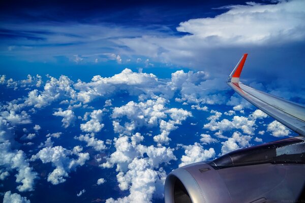 Часть самолёта в синем небе в облоках