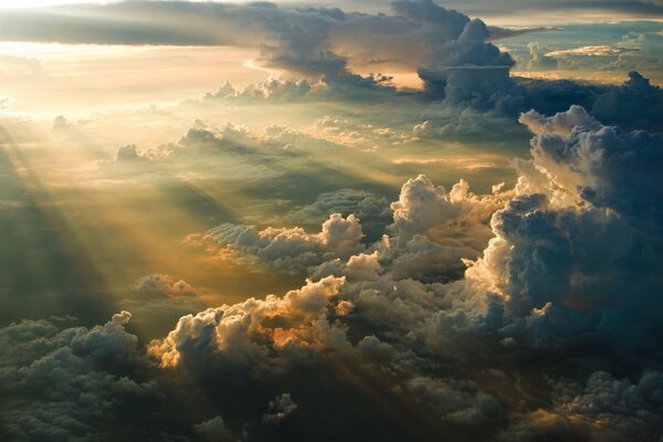 Promienie słońca o wschodzie słońca bawią się chmurami