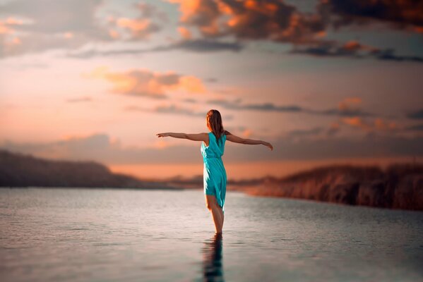 Девушка стоит в воде. Красивая фотография заката