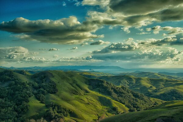 Colinas verdes se encuentran con nubes esponjosas