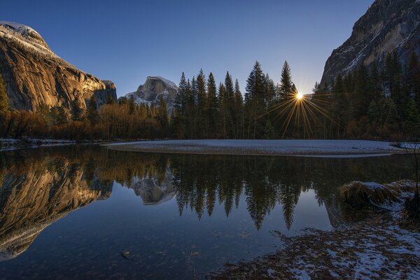 Parco Nazionale Yosemite Sierra Nevada USA tramonto sullo sfondo di montagne e rocce raggi di sole nel cielo