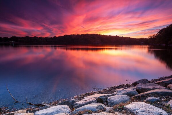 Crimson dawn on the shore of a quiet secluded lake