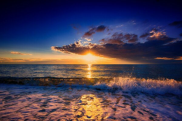 Sonnenuntergang versteckt sich hinter den Wolken am Meer