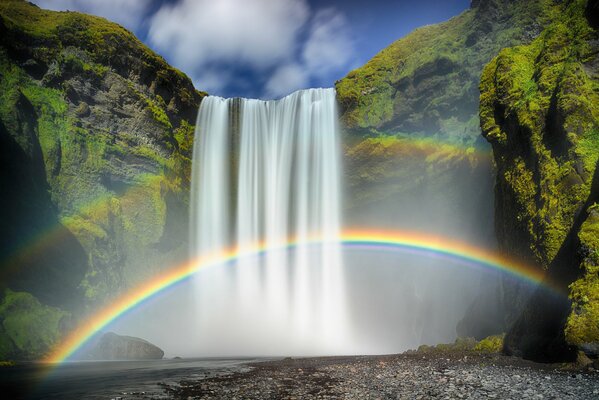 Unwirkliche Aussicht auf einen Wasserfall und einen Regenbogen