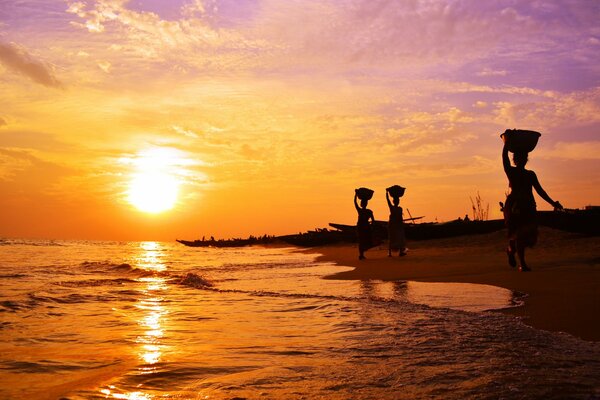 Indische Frau bei Sonnenuntergang am Meer