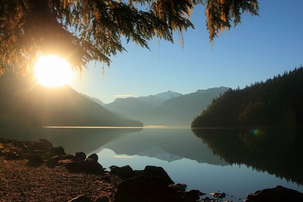 The rays of the morning sun over a clear lake in the mountains