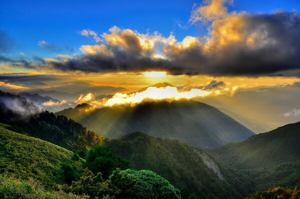 Morning. The rays of the sun over the mountains in the fog