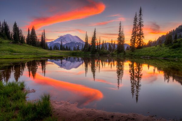 Beautiful sunset. Forest lake. Mountains