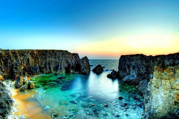 Elegante puesta de sol en la playa con rocas