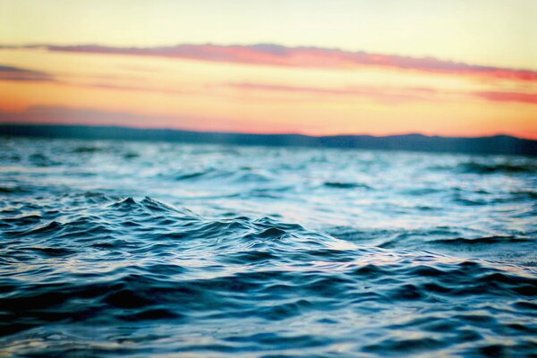 Fascinantes olas azules en el fondo de la puesta de sol