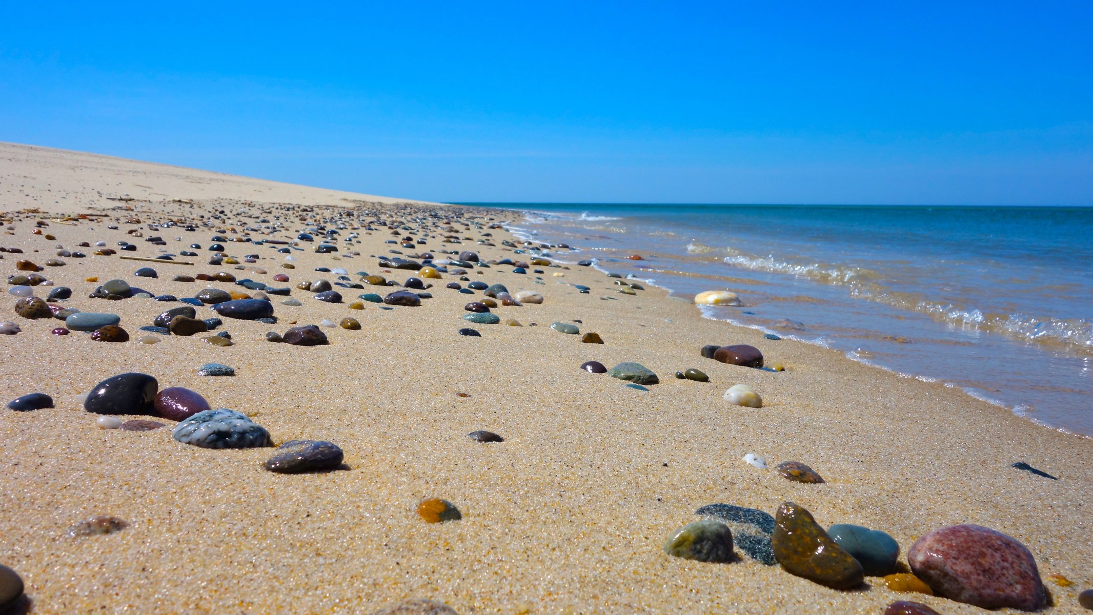 spiaggia sabbia rocce mare onde cielo