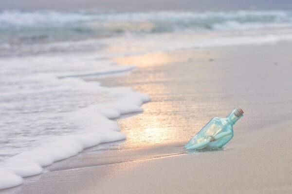 Vague mousseuse sur la plage de sable