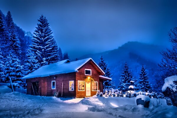 Maison solitaire dans la nuit près des montagnes