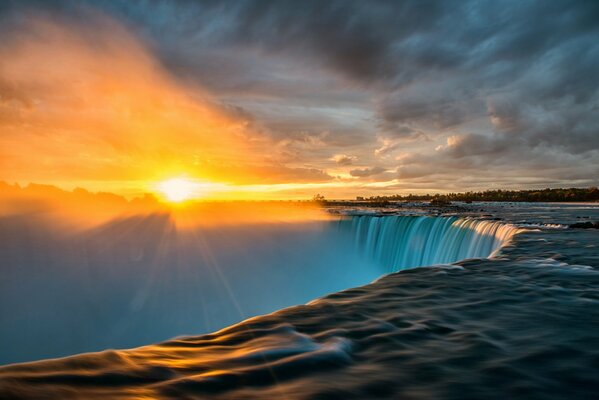 Las cataratas del Niágara en el contexto de la extraordinaria belleza del amanecer deslumbrando la vista de un hombre