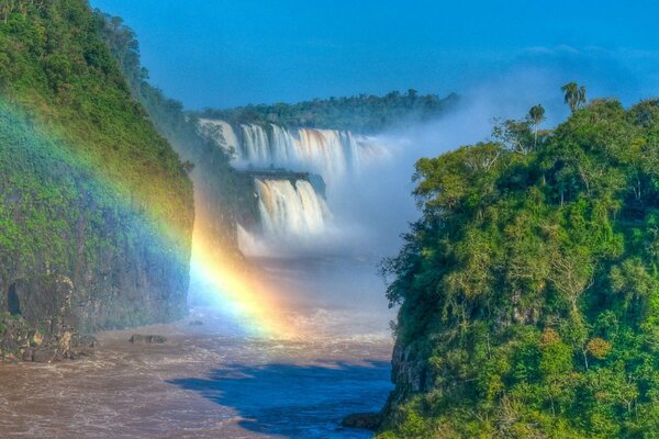 Regenbogenfall und saftiges Grün des Dschungels