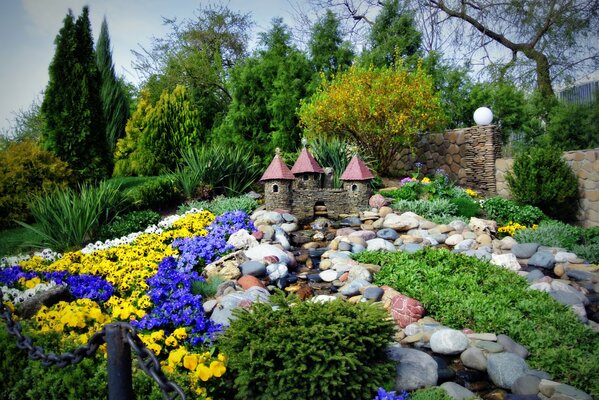 Ein kleines Schloss inmitten von Steinen und Blumen