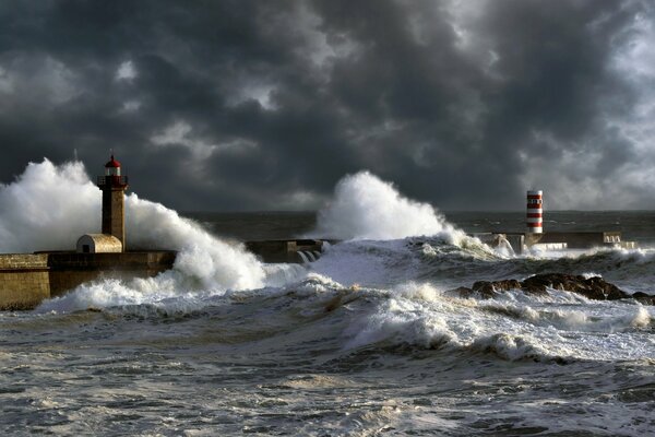 Tempesta sulla riva con le onde sopra il faro