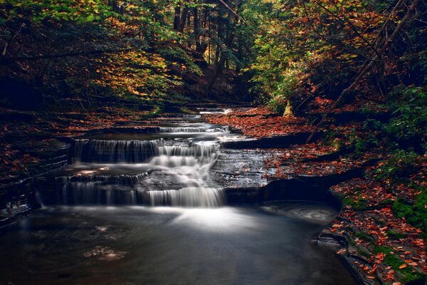 El agua que fluye infinitamente de la cascada de otoño