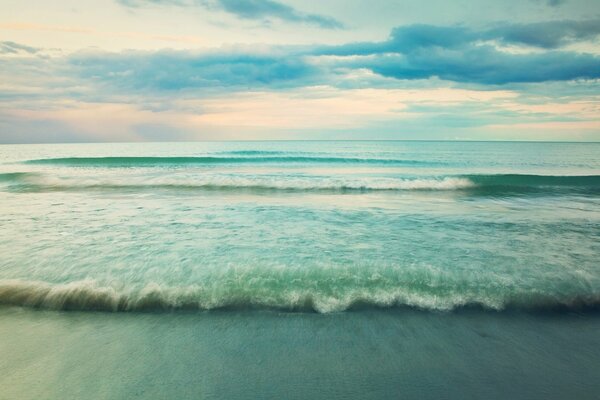 Olas de mar turquesa fusionándose con el cielo