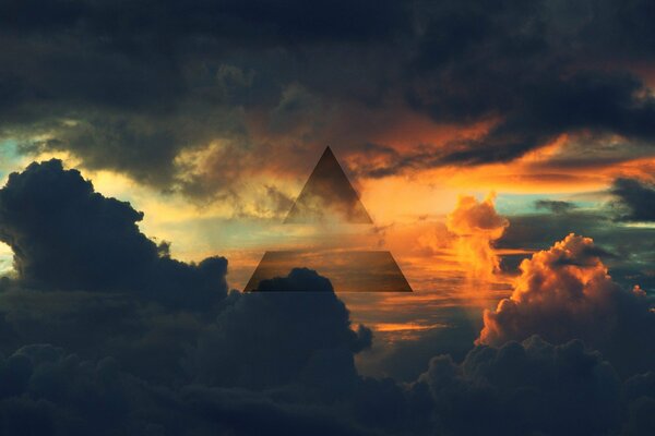 Triangle in the clouds against the background of the sky illuminated by the sun