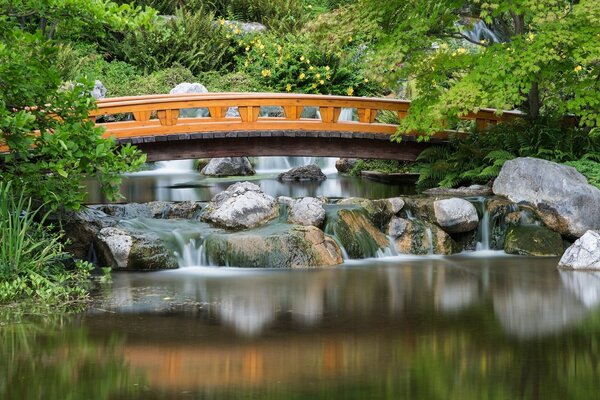 Brücke im Garten kleine Wasserfälle gießen von den Steinen