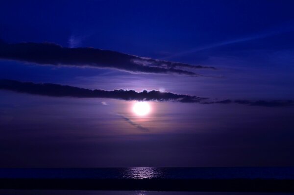 Sunset in the clouds on the sea at night