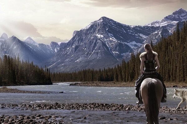 Guerriero a cavallo con un lupo vicino alle montagne