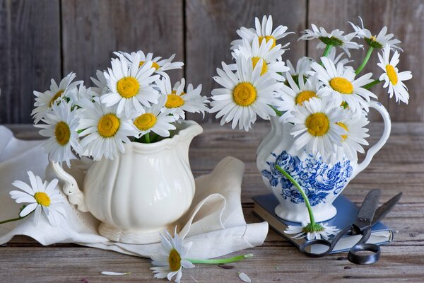 Nature morte avec des marguerites dans une cruche, des ciseaux et du tissu