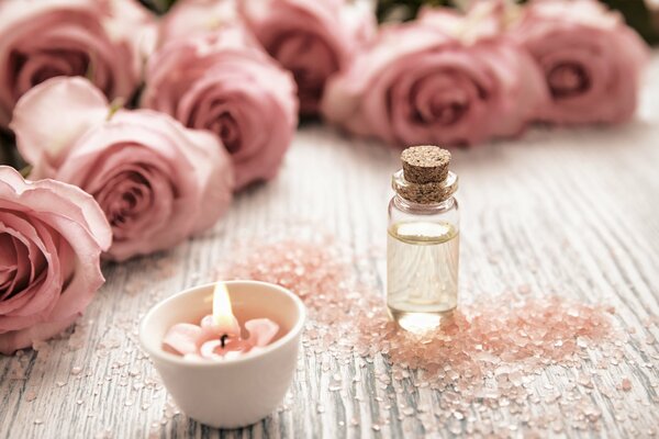 Candle on a background of pink roses