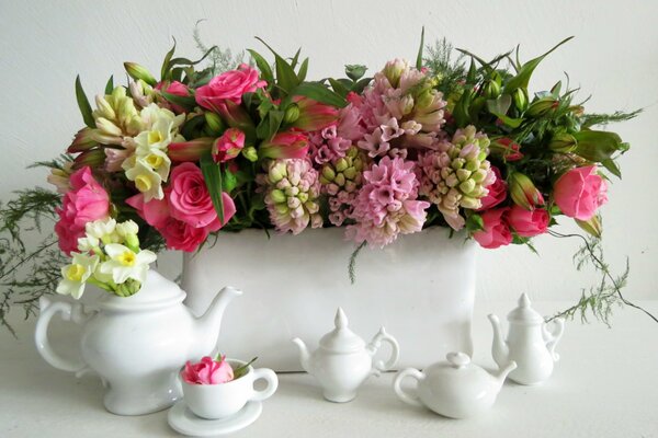 Blumen in einer Vase mit weißem Tee-Set