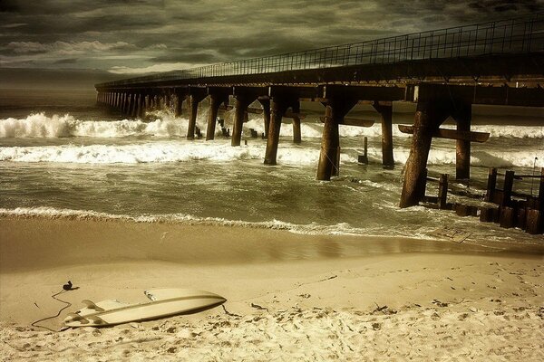 Gebrochene Brücke während eines Sturms an einem Sandstrand am Meer
