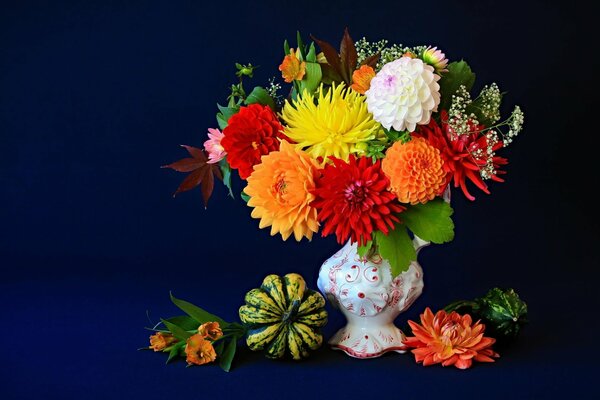 Fleurs dans un vase sur un fond bleu. Nature morte