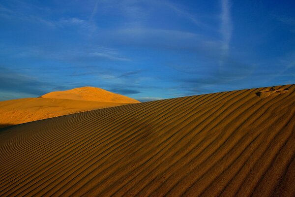 Песчаные барханы в жаркой, солнечной пустыне