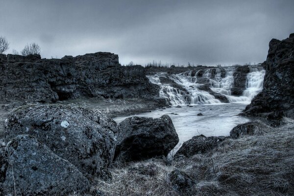 Dunkle Landschaft. Wasserfall in den Felsen