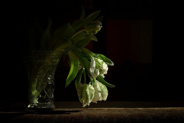 Welkende Blumen in einer Kristallvase