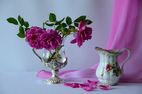 Sur la table se trouve un vase avec des fleurs rouges