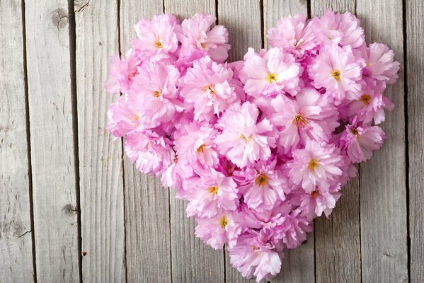 Heart of flowers on a wooden background