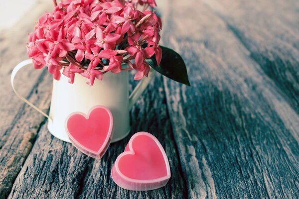 Coeurs roses près d une tasse blanche avec des fleurs roses