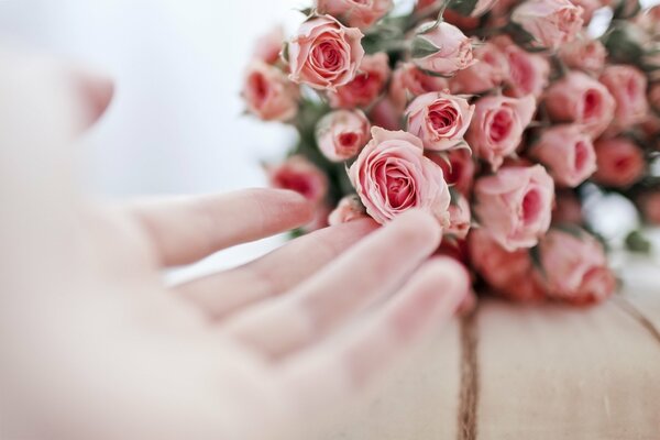 The hand reaches for the wedding bouquets