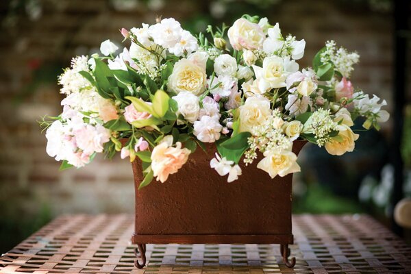 A vase with white roses on the table