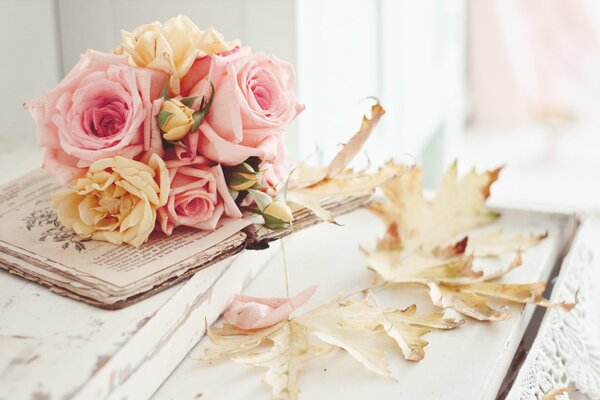 Naturaleza muerta de otoño con un libro y rosas