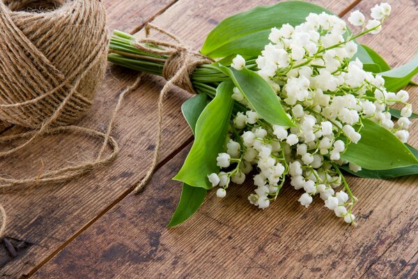 Bouquet di mughetti avvolto con una corda