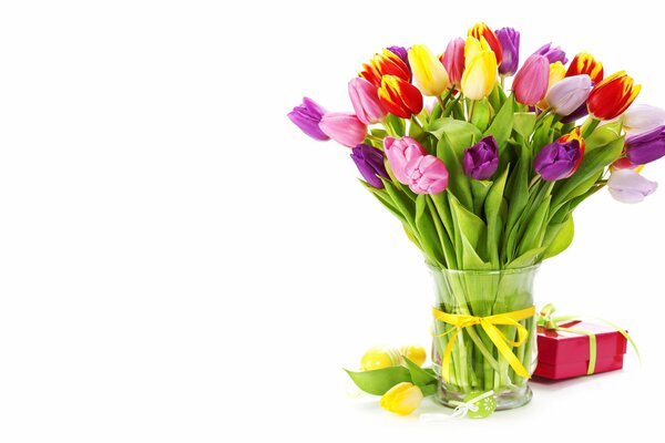 Ein Strauß Tulpen in einer Vase und eine Schachtel mit einem Geschenk